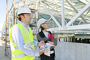 Man engineer and woman architect at a construction site. Building, development, teamwork and people concept
