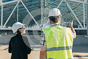 Man engineer and woman architect at a construction site. Building, development, teamwork and people concept