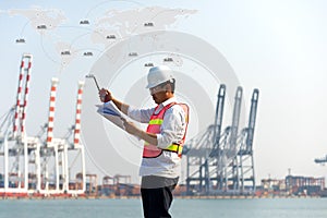 The man engineer working with container Cargo freight ship in shipyard at dusk for Logistic Import