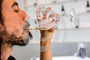 Man enjoy the taste of white wine glass