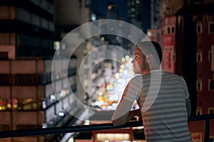 Man enjoying city view from balcony against street market