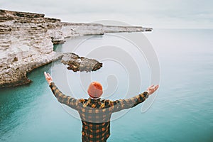 Man enjoying cold sea view alone raised hands