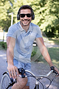man enjoying music using earphones while commuting on bicycle