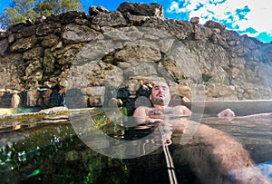 Man enjoying and relaxing in natural thermal water roman spa