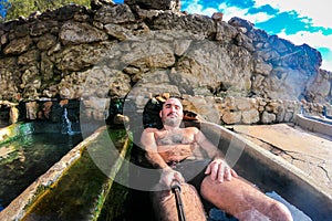 Man enjoying and relaxing in natural thermal water roman spa