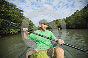 Man enjoying river kayaking through mangrove jungl