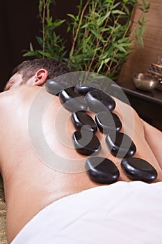 Man enjoying stone massage in salon