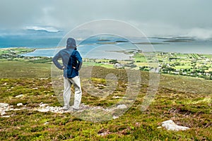 Man enjoying view on Clew Bay from Croagh Patrick, Westport, county Mayo, Ireland