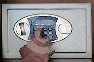 A man enters the combination lock on the safe in the office. Close-up safe storage of money, jewelry, stocks. Protection from