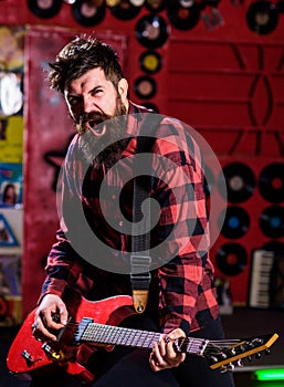 Man with enthusiastic face holds guitar, singing song, play music,