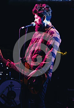 Man with enthusiastic face holds guitar, singing song, play music,