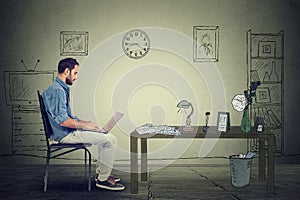 Man entrepreneur working on laptop in office sitting on chair