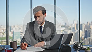 Man entrepreneur writing papers in contemporary office. Successful boss signing