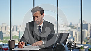 Man entrepreneur writing papers in contemporary office. Successful boss signing