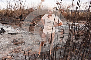 Man Inspecting a brush fire photo