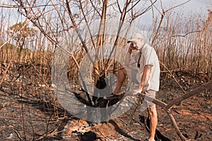 Man Inspecting a brush fire photo