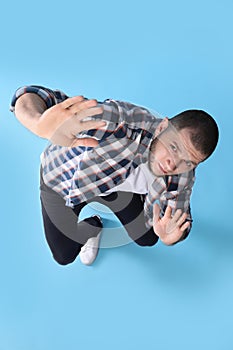 Man evading something on light blue background, above view