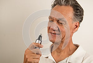 Man Examine his Nose Hair Trimmer