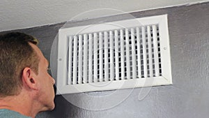 Man Examining an Air Vent