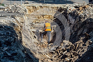 Man examining an excavation of old broken water supply or sewer pipeline