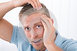 Man Examining His Hair