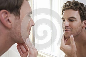 Man Examining His Stubble In Mirror