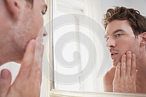 Man Examining His Stubble In Mirror