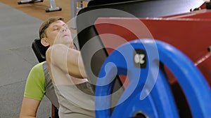 A man with excess weight doing leg presses on the simulator in the gym. Fitness training. Healthy lifestyle concept