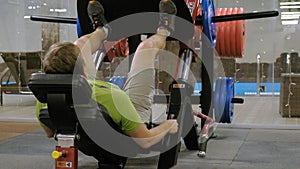 A man with excess weight doing leg presses on the simulator in the gym. Fitness training. Healthy lifestyle concept