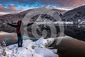 Man Excited by The Beauty of Lake and Mountains Landscape in Winter at Dusk