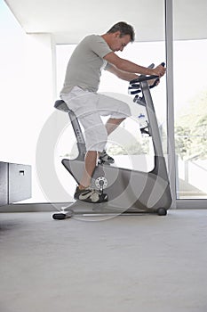 Man On Exercise Bike Pedaling At Home