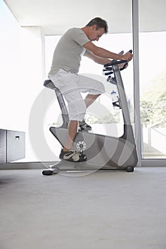 Man On Exercise Bike Pedaling At Home photo