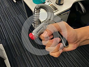 Man exercise his hand by strength handgrip to prevent office syndrome photo