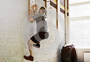 Man exercise on peg board in gym