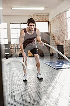 Man exercising with battling rope