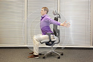 Man exercising on chair in office, healthy lifestyle