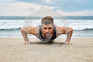 Man Exercising, Doing Push Up Exercises On Beach. Fitness Workout photo