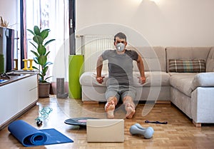 Man exercising doing workout at home in mask