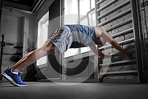 man exercising on gymnastics wall bars in gym