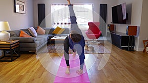 Man exercising indoors, home yoga Twisting Lunge Parivrtta Anjaneyasana