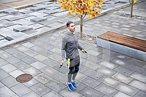 Man exercising with jump-rope outdoors