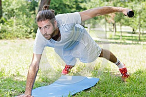 Man exercising midsection core muscles doing side plank exercise