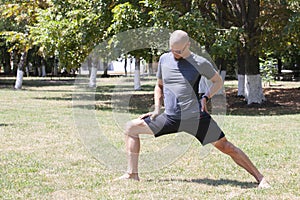 Man exercising in park. Smiling caucasian male doing core workout on grass