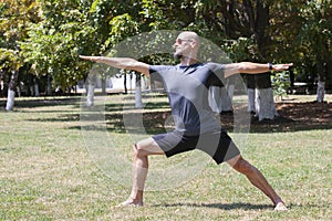 Man exercising in park. Smiling caucasian male doing core workout on grass