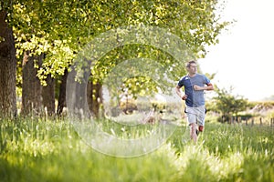 Man Exercising Running Through Countryside Field