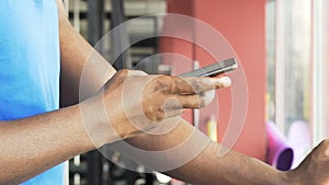 Man exercising on stationary bike at slow pace, using mobile phone, application