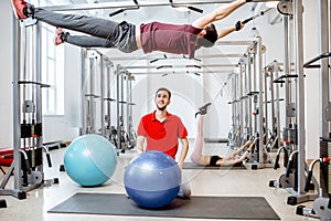 Man exercising with trainer at the rehabilitaion gym