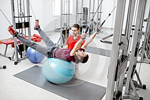 Man exercising with trainer at the rehabilitaion gym