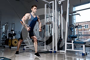 Man is exercising on a training machine in the gym