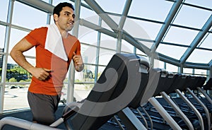 Man Exercising On Treadmill In Gym